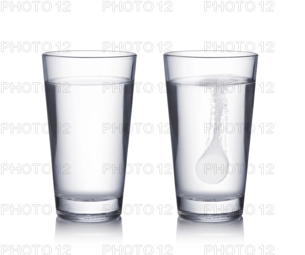 Glass with effervescent tablet in water with bubbles on white background