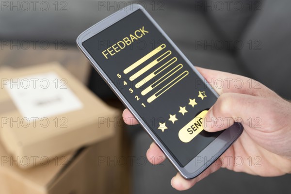 close-up of person giving positive feedback on smartphone after delivery of ordered items, customer review and feedback concept
