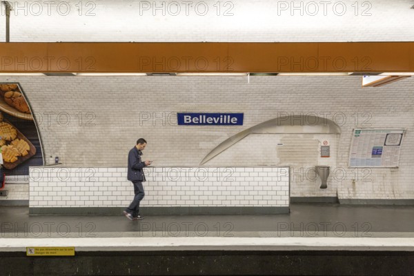Paris, France, May 12, 2017: A man walking past a sign at Belleville Metro station, Europe