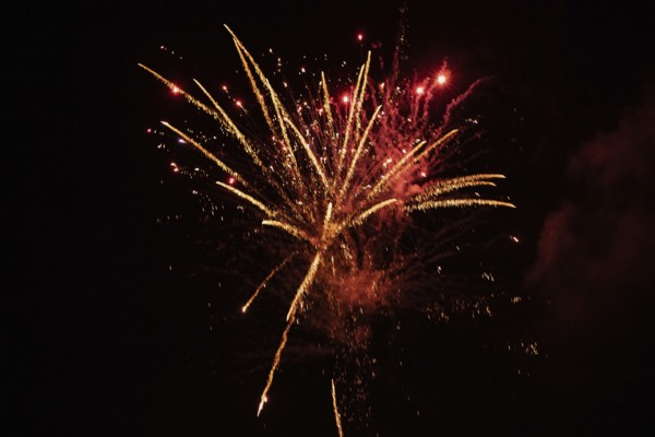 New Year's Eve fireworks night sky with golden and reddish sparks
