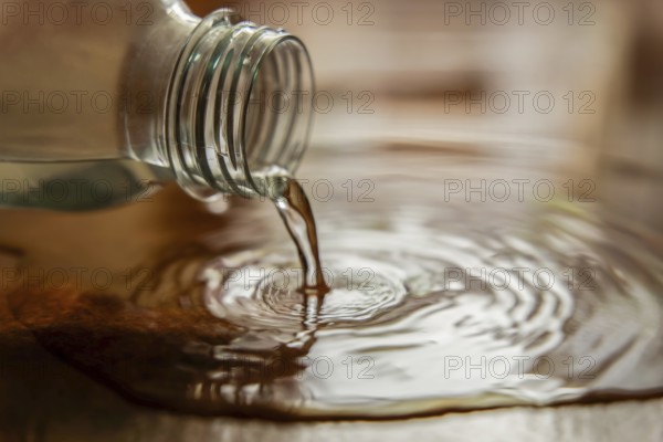 Close-up shot of a plastic water bottle spilling water on the ground