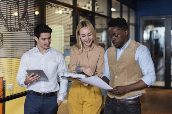 Smiley coworkers looking documents together