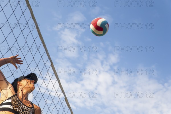 Two female athletes playing beach volleyball