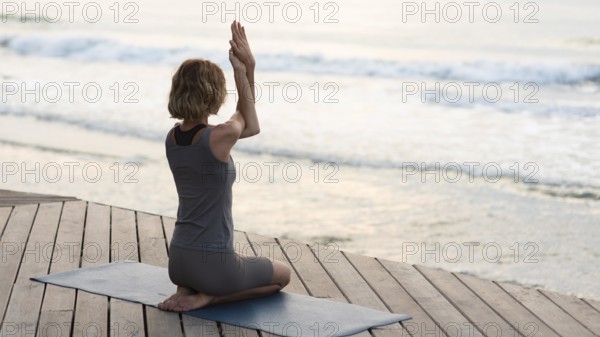 Full shot woman doing yoga pose mat outside