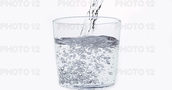 Water being poured into Glass against White Background