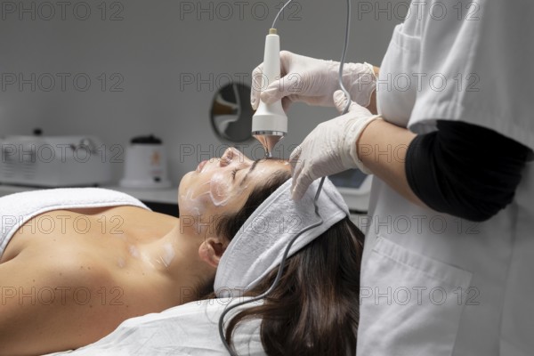 Young woman having facial treatment