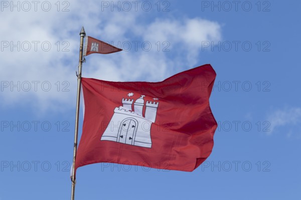Red flag with the coat of arms of Hamburg against a blue sky in Hamburg, Germany, Europe
