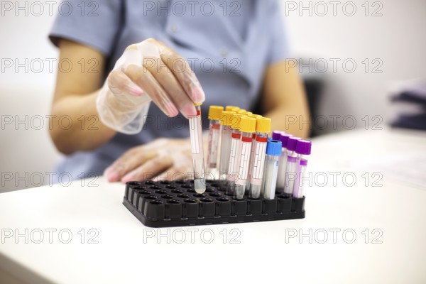 Female doctor holding Blood test tubes in hands. Close up
