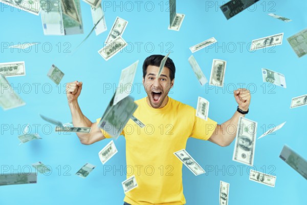 Happy excited man standing under money rain banknotes falling down. Success, business, and fortune concept