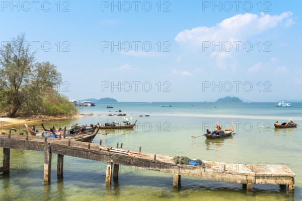 Locals on the beach and on their long-tail boats at the west side beach Ao Mae Mai on the island Ko Phayam in Thailand