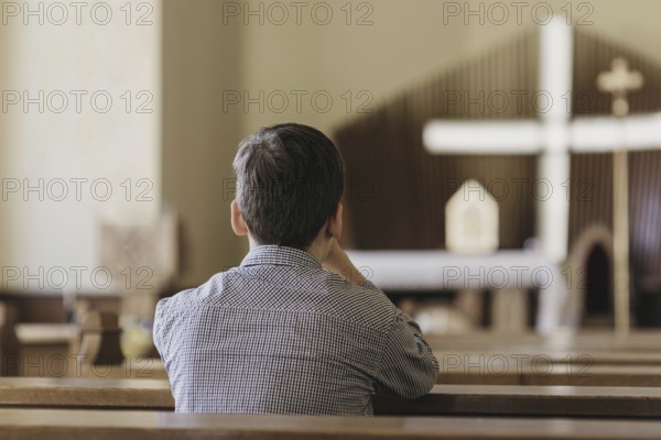 Back view young boy praying church. High resolution photo