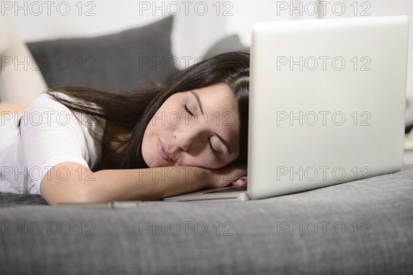 Tired woman fallen asleep over the laptop keyboard