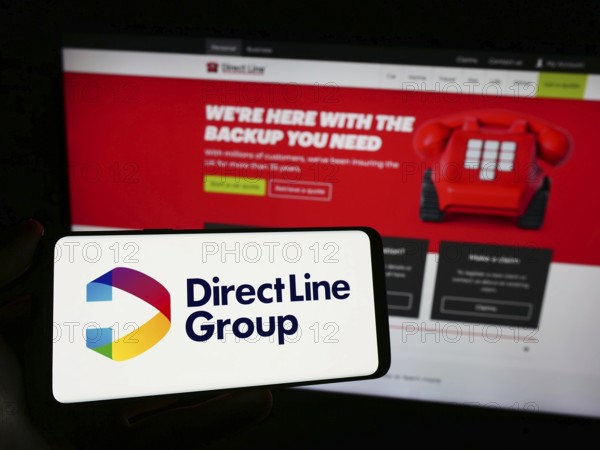 Stuttgart, Germany, 12-08-2023: Person holding smartphone with logo of British financial company Direct Line Insurance Group plc in front of website. Focus on phone display, Europe