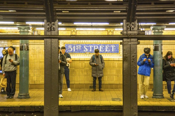 Waiting underground passengers at 51st St subway station, New York City