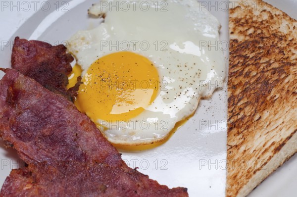 Eggs sunny side up with bacon and toast typical english breakfast