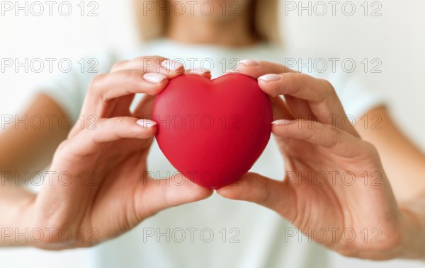 Defocused woman holding heart shape