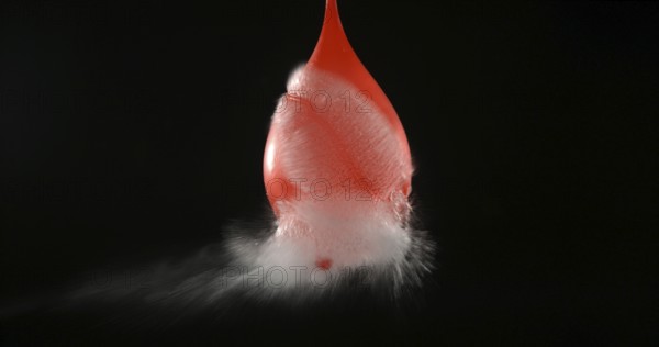 Shot Breaking Water Filled Red Balloon