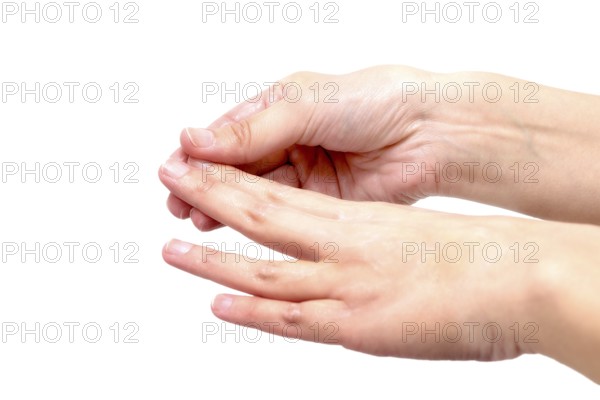 Close-up of female hands while applying moisturizing lotion in order to repair damaged and dry skin, on grey background