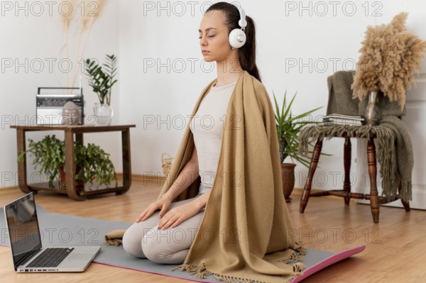 Woman meditating home with headphones