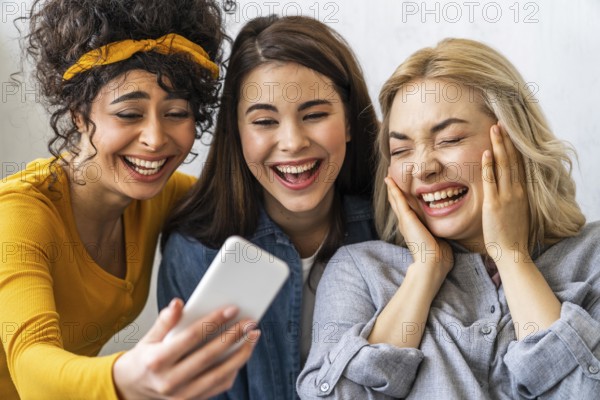 Front view three happy women smiling taking selfie