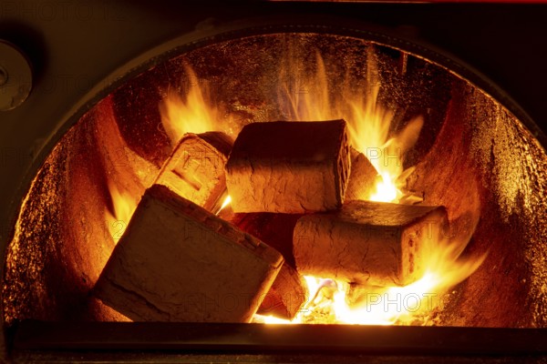 Wood briquettes (ruf type), made of beech and oak burning inside the wood fuel boiler. Alternative fuel, eco fuel, bio fuel