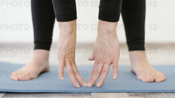 Close up hands touching yoga mat