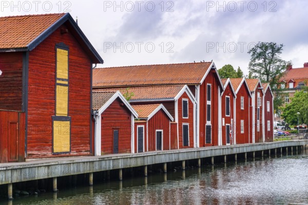 Hudiksvall, Sweden - 7 July, 2021: red and brown wooden warehouses along the waterfront in Hudiksvall