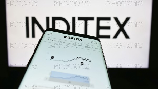 Stuttgart, Germany, 04-16-2023: Mobile phone with website of Industria de Diseno Textil S.A. (Inditex) on screen in front of business logo. Focus on top-left of phone display, Europe