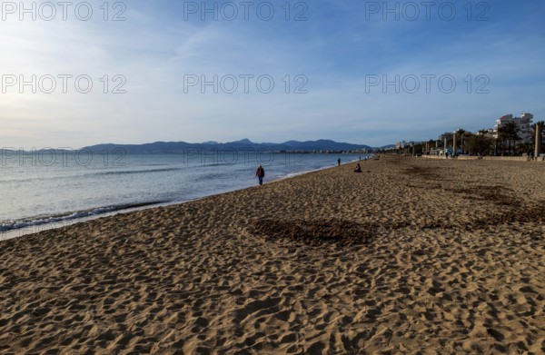 Beach walkers, relaxed evening mood in the low season on the beach Playa Arenal, Playa de Palma, Ballermann zone, Palma de Majorca, Majorca, Balearic Islands, Spain, Europe