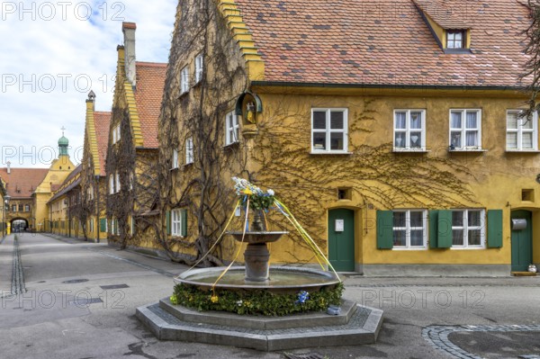 Building in the historic residential complex Fuggerei and Fuggerei Brunnen in the old town of Augsburg, Augsburg, Swabia, Bavaria, Germany, Europe