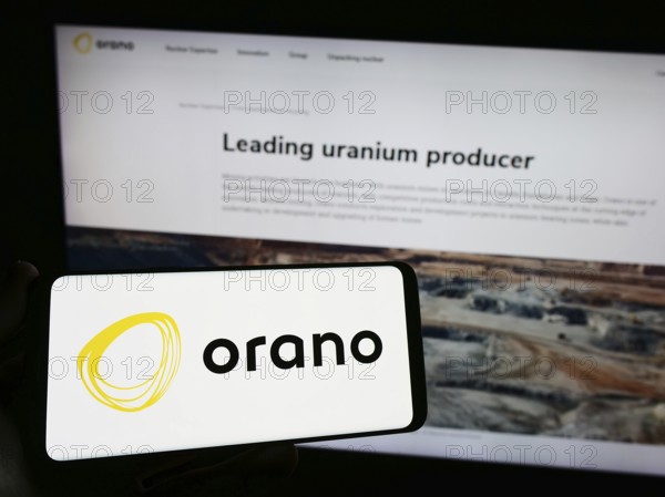 Stuttgart, Germany, 09-01-2023: Person holding smartphone with logo of French nuclear energy company Orano S.A. on screen in front of website. Focus on phone display, Europe