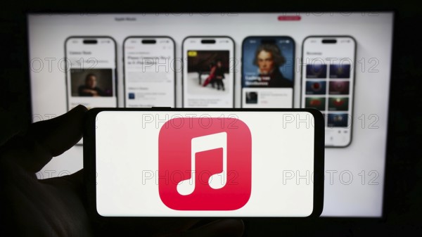 Stuttgart, Germany, 09-23-2023: Person holding smartphone with logo of streaming service platform Apple Music on screen in front of website. Focus on phone display, Europe