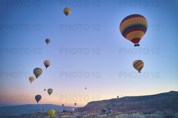 Lots of hot air balloons above fairy chimneys rock formations. Aerial view of Cappadocia. Goreme, Nevsehir province, Turkey, Asia