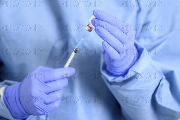 Doctor holding a syringe with a single bottle vial of Covid-19 vaccine. Concept fight against virus. Close up detail. Medical concept vaccination hypodermic injection treatment. High quality photo