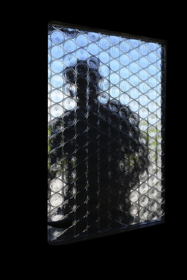 A stranger opens the front door, A dark figure tries to look through the opaque glass pane of a front door, Symbolic image of a house burglary