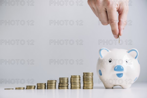 Human hand inserting coin piggybank