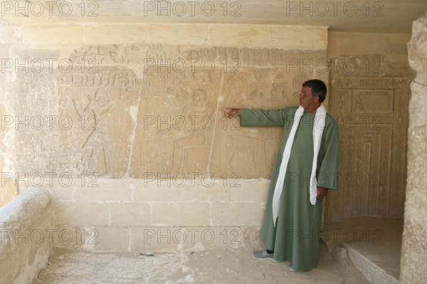 Tourist guide shows relief in Mastaba, near Sakkara, Egypt, Africa