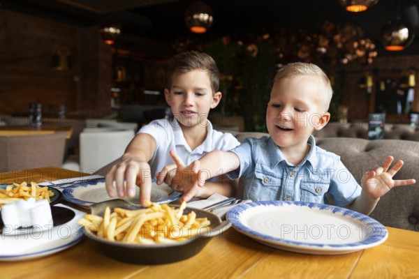 Medium shot boys eating fries