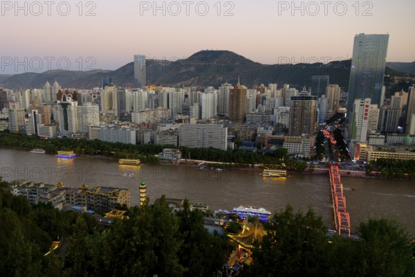 The Yellow River or Huang He in Lanzhou with the city skyline at sunset