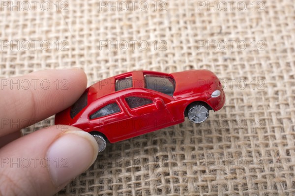 Colorful little toy car in hand on white background