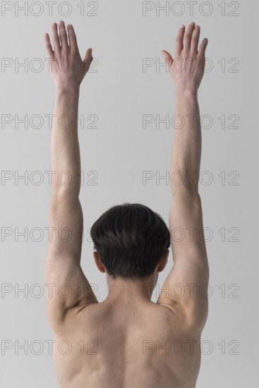 Back view naked man with arms raised