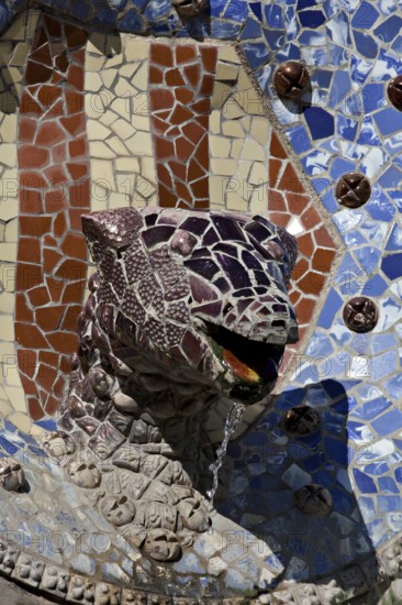 The dragon's head fountain in the middle of the staircase at the entrance to Parc Güll, the Gaudi-designed park in Barcelona, Spain, Europe