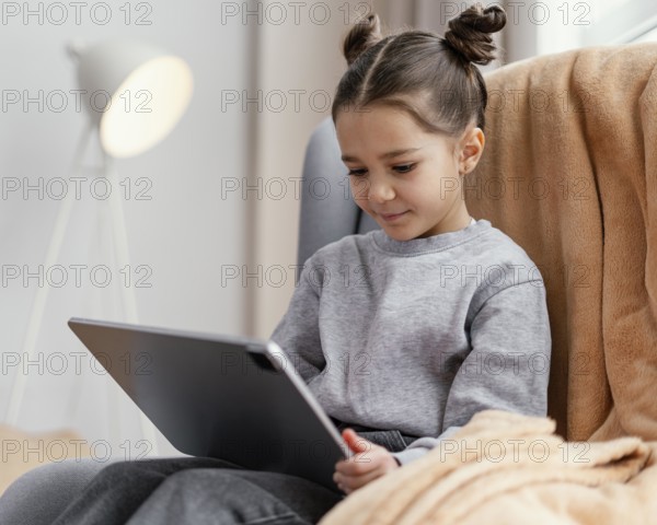 Little girl couch using tablet