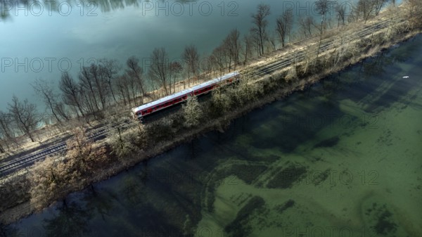 A red local railway runs on an embankment between two turquoise-coloured waters, drone shot, Upper Bavaria, Bavaria, Germany, Europe