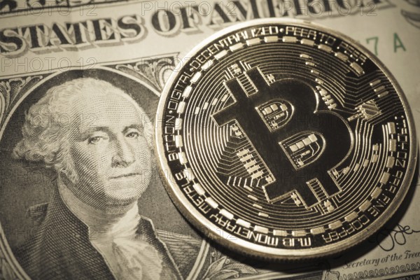 One Bitcoin on dollar banknote. Closeup, macro shot