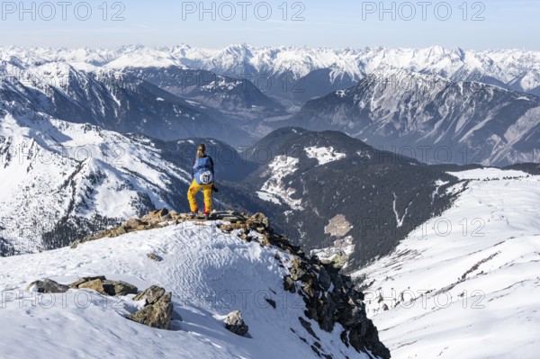 View of the Inn Valley, mountaineer at the summit of the Pirchkogel, mountains in winter, Sellraintal, Kühtai, Tyrol, Austria, Europe