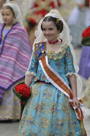 Fallas festival, girl in a traditional costume during the parade in the Plaza de la Virgen de los Desamparados, Valencia, Spain, Europe