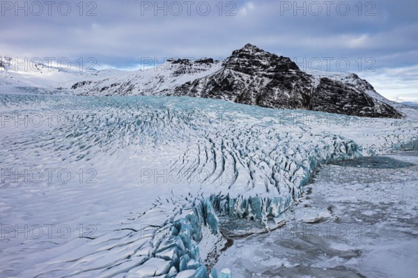 Snow-covered icebergs in the Fjallsarlon glacier lagoon, with the Öraefajökull glacier behind, drone shot, Sudurland, Iceland, Europe