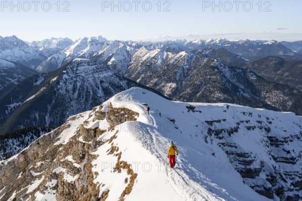 Two ski tourers at the summit of Schafreuter, view of snowy mountain panorama, Karwendel, Tyrol, Austria, Europe