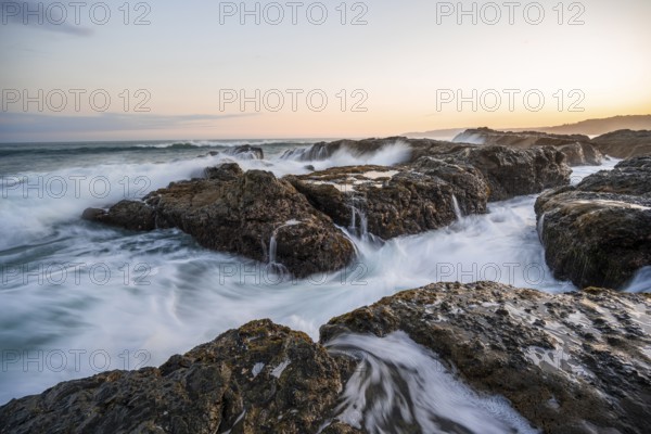Waves washing over rocks by the sea, long exposure, coastal landscape at sunset, Playa Cocalito, Pacific coast, Nicoya Peninsula, Puntarenas province, Costa Rica, Central America